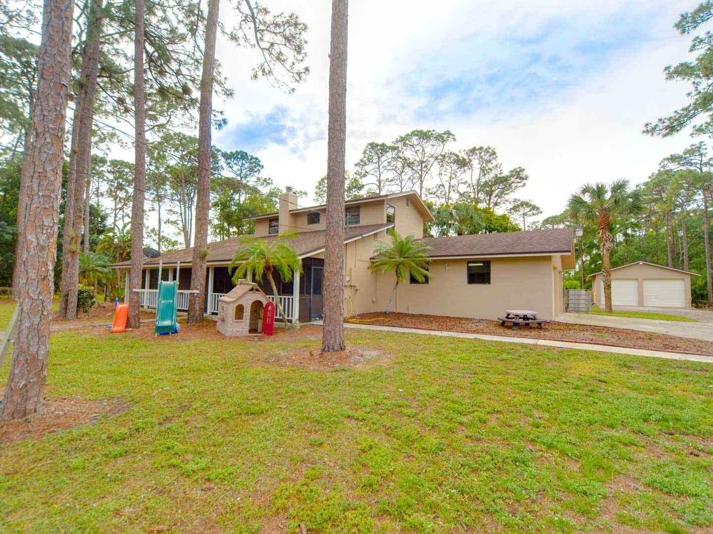 2477 West G Road Loxahatchee, FL 33470 - Photo 8 of 61 a view of a swimming pool with outdoor seating and a yard