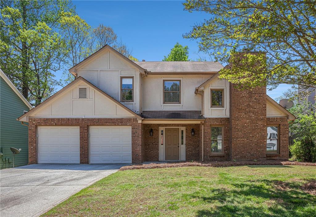 a front view of a house with a yard and garage