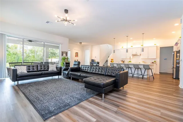 a living room with furniture and a wooden floor