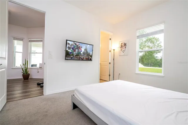 a bedroom with a bed and a lamp on dresser