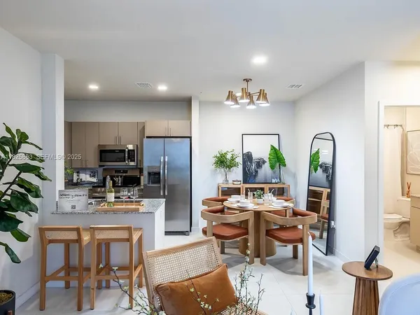 a living room with furniture a chandelier and a dining table
