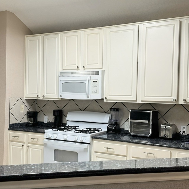2224 Kerr Trail Cedar Park, TX 78613 - Photo 7 of 15 a kitchen with a stove and white cabinets