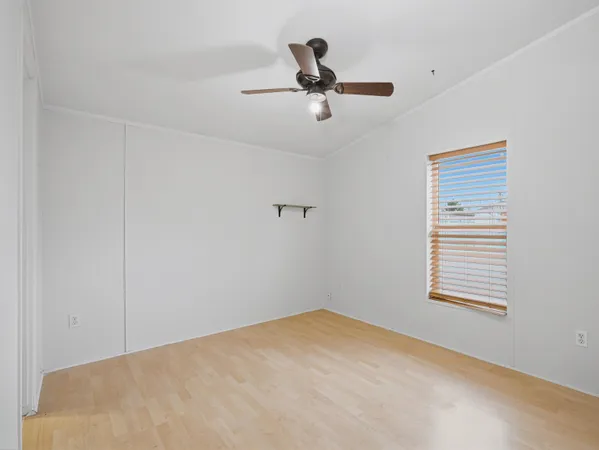 a view of a room with ceiling fan and window