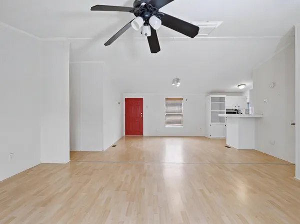 a view of an empty room and window ceiling fan
