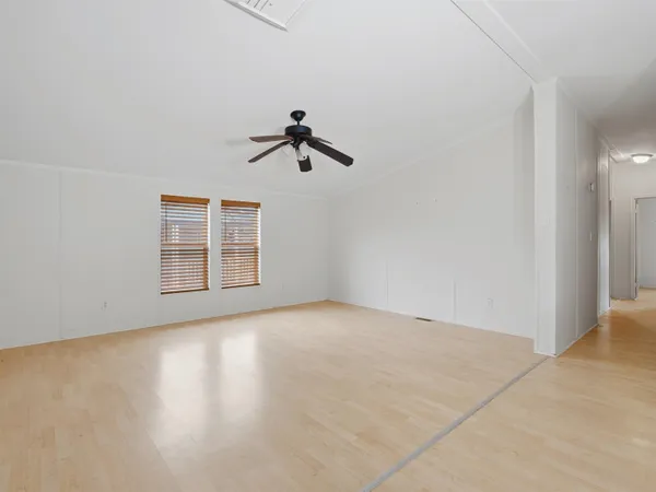 an empty room with windows and ceiling fan view