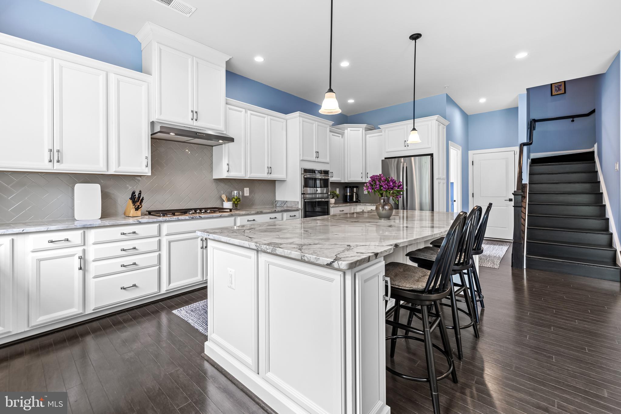 14309 Oak Meadow Road Baldwin, MD 21013 - Photo 35 of 102 a kitchen with stainless steel appliances kitchen island granite countertop a stove a sink and white cabinets with wooden floor