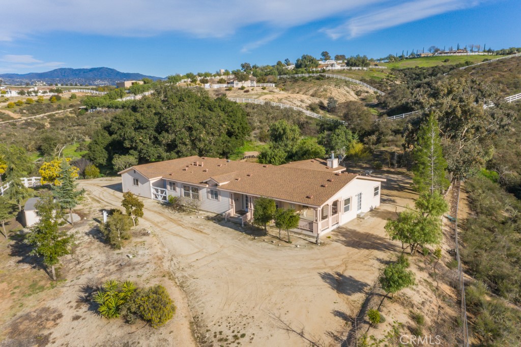 an aerial view of residential houses with outdoor space and trees