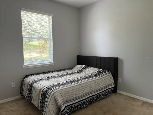 a bed sitting in a bedroom next to a window