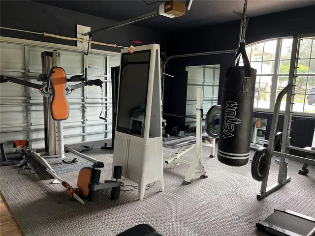 a gym room with lots of white furniture and a window