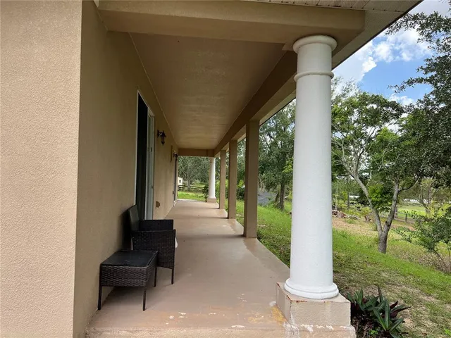 a view of a porch with chairs and backyard