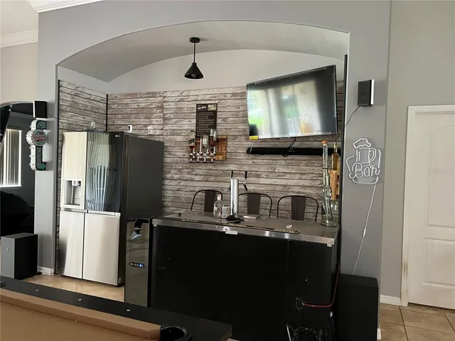 a kitchen with refrigerator a microwave oven and a sink with wooden floor