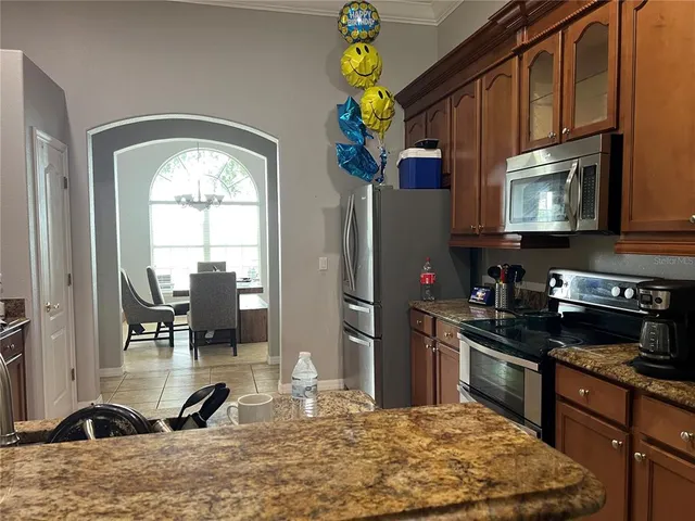 a kitchen with stainless steel appliances granite countertop a stove a sink and a microwave