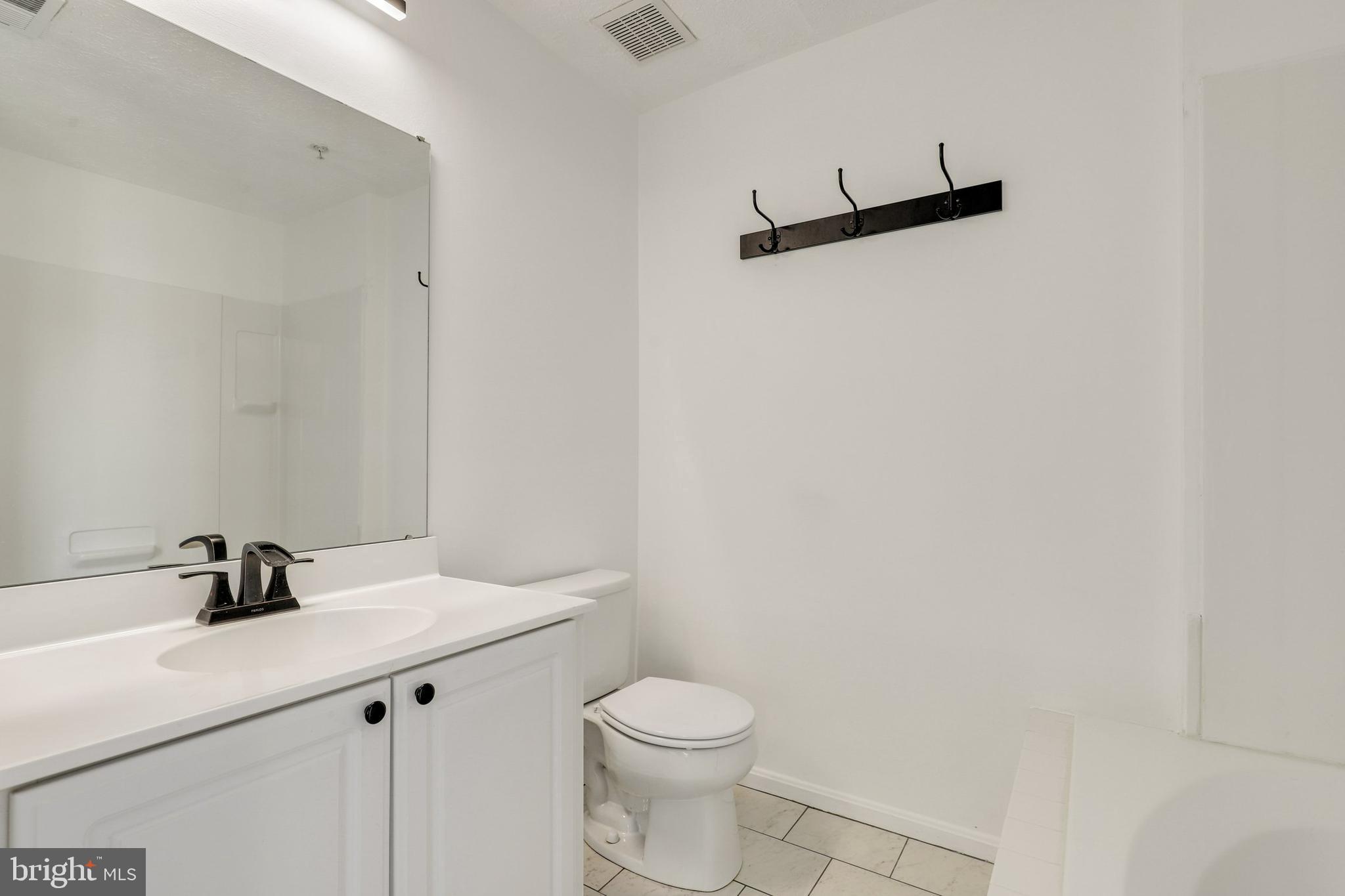 2444 Blue Spring Court, Unit 303 Odenton, MD 21113 - Photo 16 of 33 a bathroom with a sink a toilet and a mirror