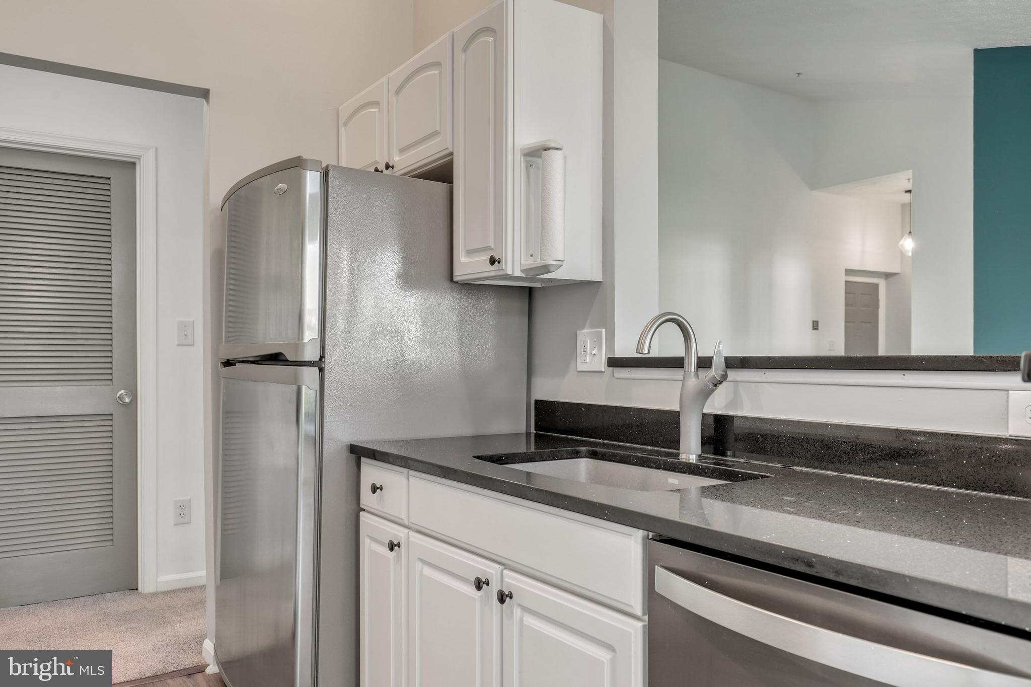2444 Blue Spring Court, Unit 303 Odenton, MD 21113 - Photo 7 of 33 a kitchen with a refrigerator and a sink