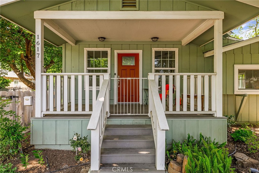 a view of a house with a small yard and wooden floor and fence