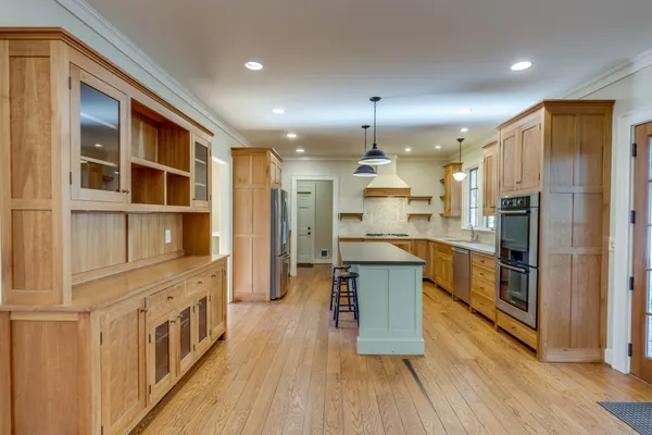 a kitchen with stainless steel appliances granite countertop a sink a stove and a refrigerator