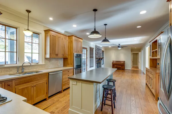 a kitchen with stainless steel appliances granite countertop a stove and a wooden floors