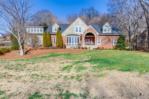 a front of a house with yard and garage