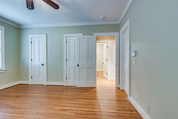 a view of a hallway with wooden floor and staircase