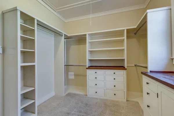 a view of walk in closet with empty racks