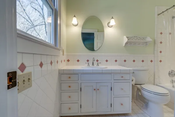 a bathroom with a granite countertop shower a sink and a mirror