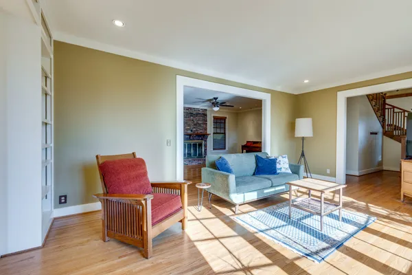 a view of a livingroom with furniture a ceiling fan and wooden floor
