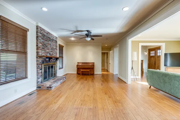 a large kitchen with stainless steel appliances kitchen island a large counter top and wooden floors