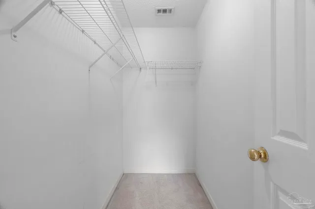 a view of an empty room with a chandelier fan