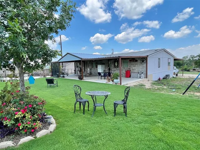 a view of an house with backyard and sitting area