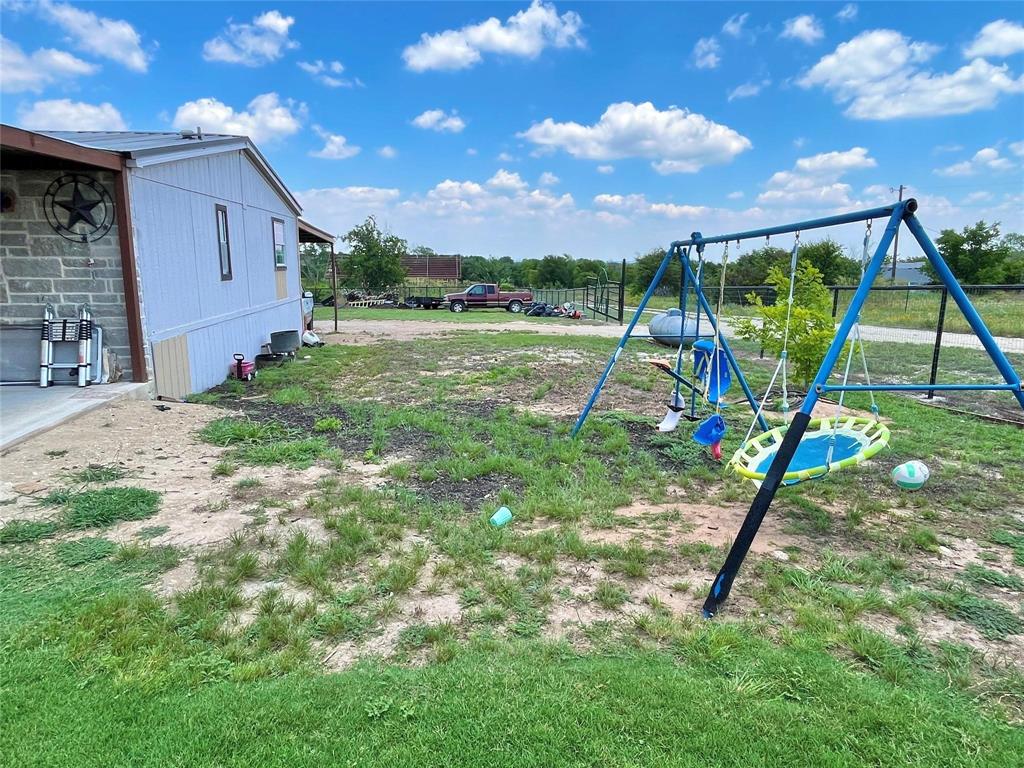 119 Overlook Trail Azle, TX 76020 - Photo 5 of 20 a view of a backyard with a slide trees and wooden fence