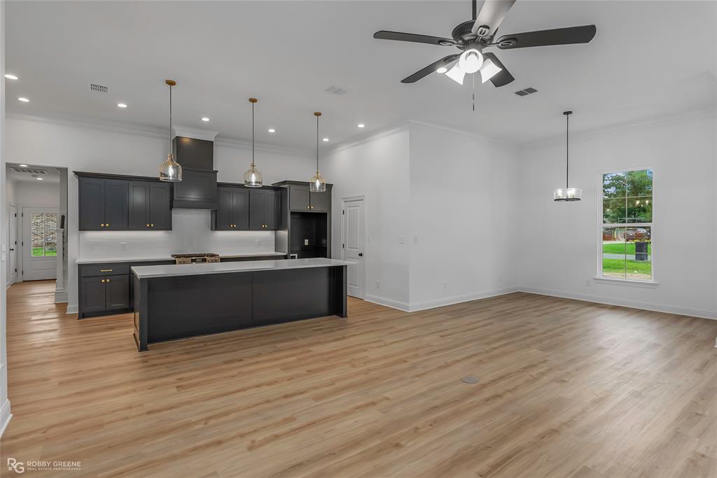 231 Ramsey Road Stonewall, LA 71078 - Photo 16 of 39 a large kitchen with stainless steel appliances kitchen island a large counter top and a wooden floors