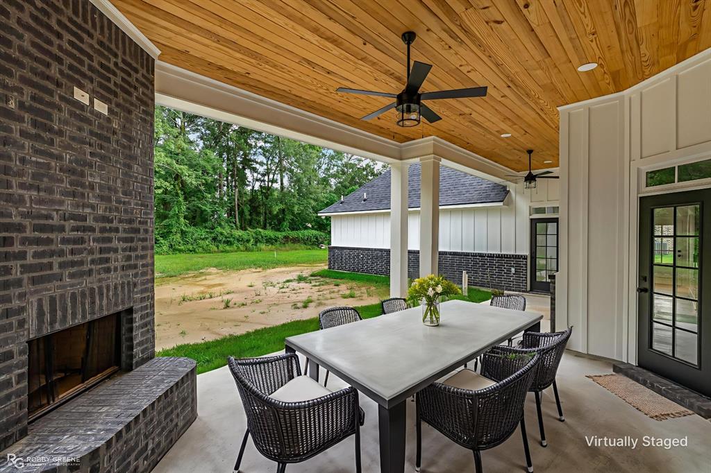 231 Ramsey Road Stonewall, LA 71078 - Photo 35 of 39 a patio with a table and chairs and a barbeque