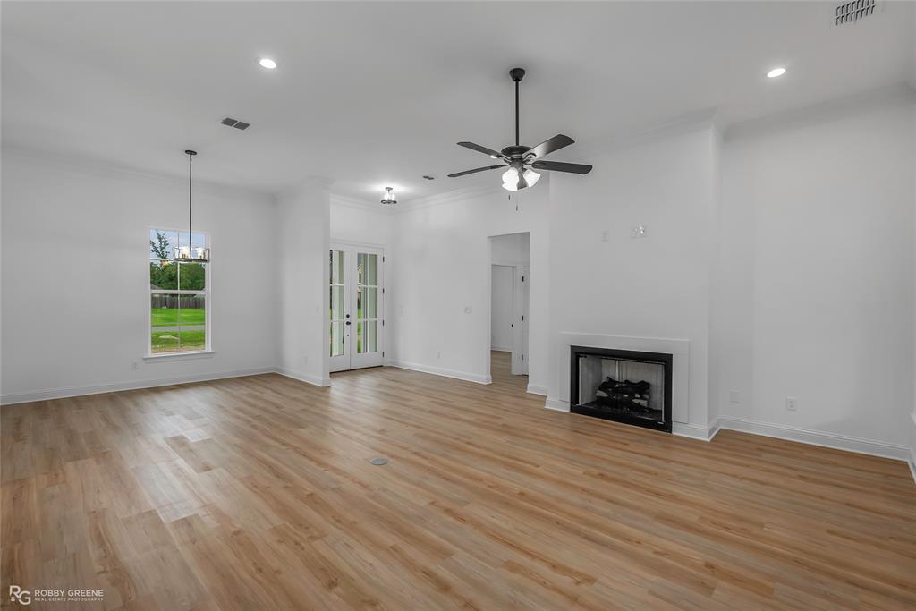 231 Ramsey Road Stonewall, LA 71078 - Photo 5 of 39 a view of empty room with wooden floor fireplace and window