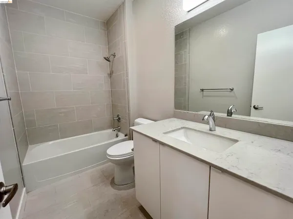 a bathroom with a granite countertop sink a toilet and shower
