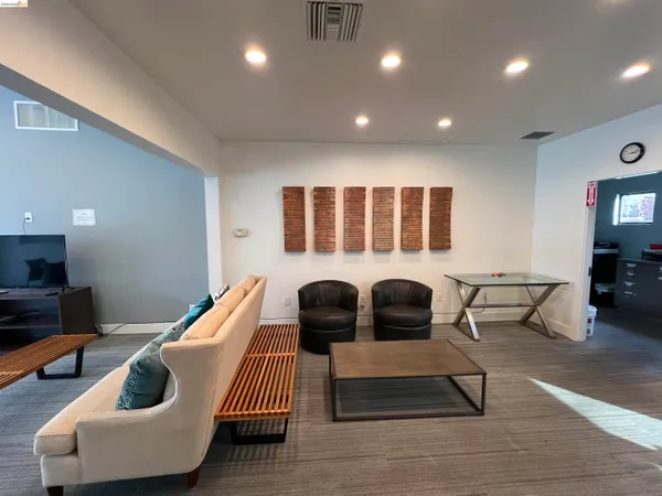 a living room with furniture and a wooden floor