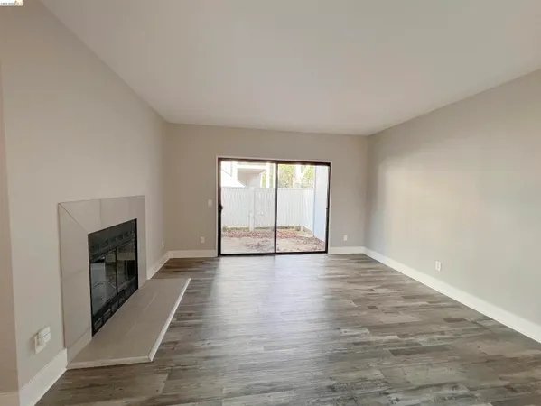 wooden floor fireplace and windows in an empty room