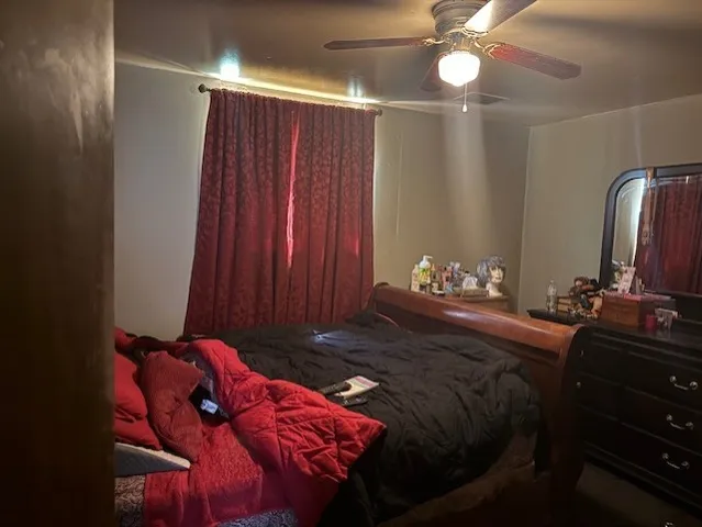 a bed sitting in a bedroom next to a window and a chandelier