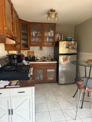 a kitchen with a stove a refrigerator and cabinets