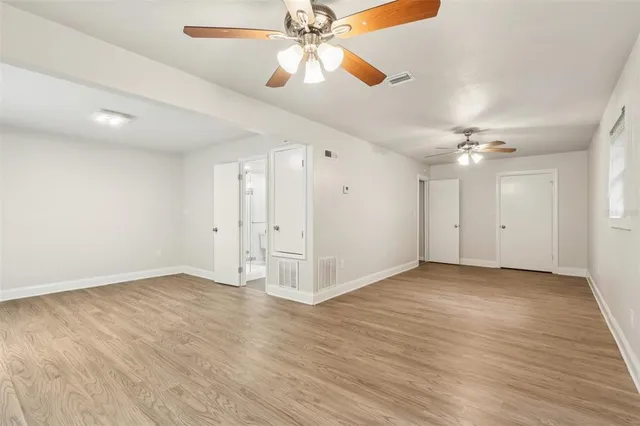 a view of an empty room and a ceiling fan window