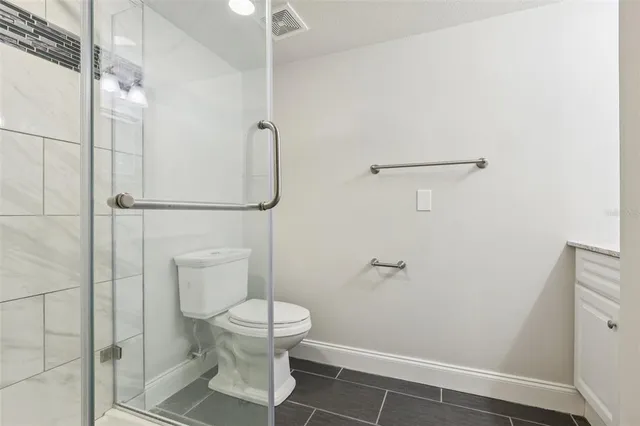a white toilet sitting next to a shower