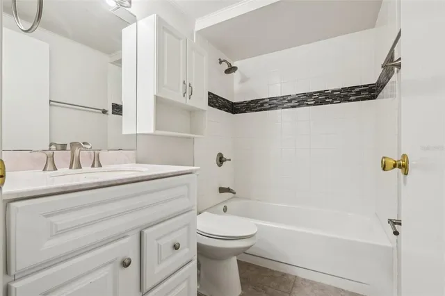 a bathroom with a granite countertop sink a toilet and shower