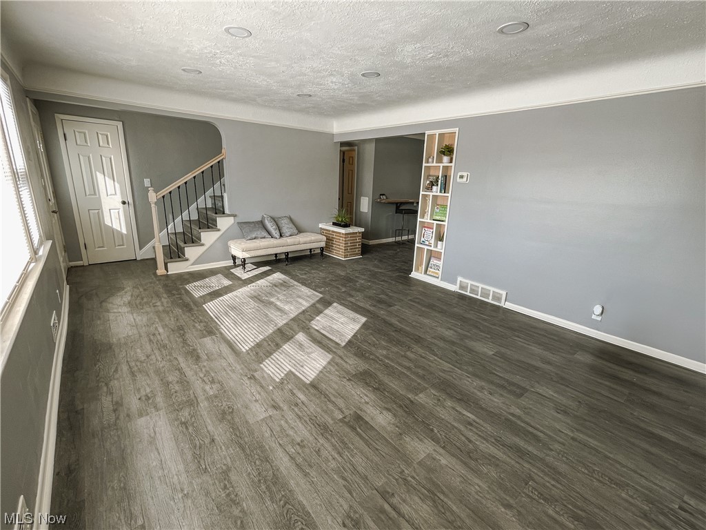 24709 Emery Road Warrensville Heights, OH 44128 - Photo 25 of 34 Unfurnished room featuring dark wood-type flooring and a textured ceiling