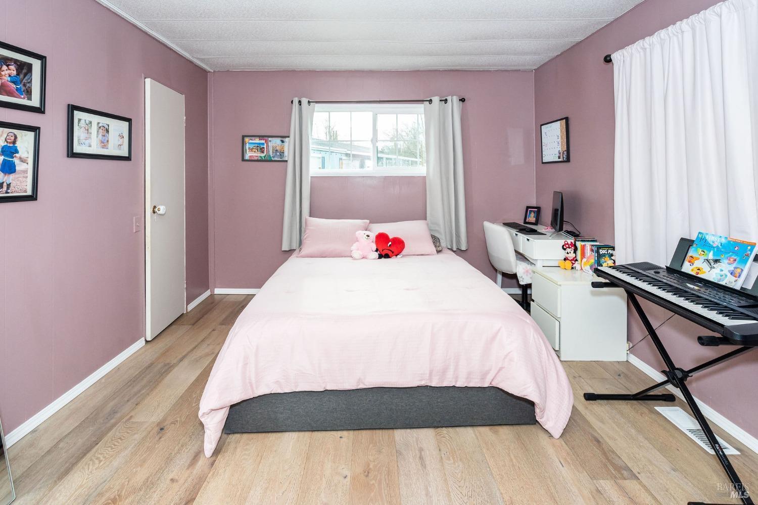 Oversize primary bedroom with walk in closet behind door in photo.