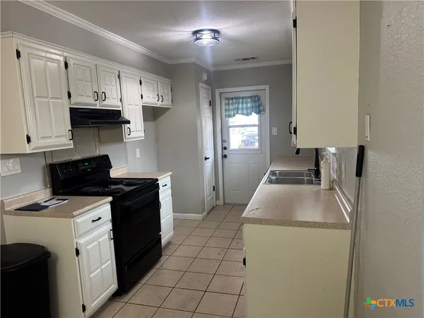 a kitchen that has a sink and a stove