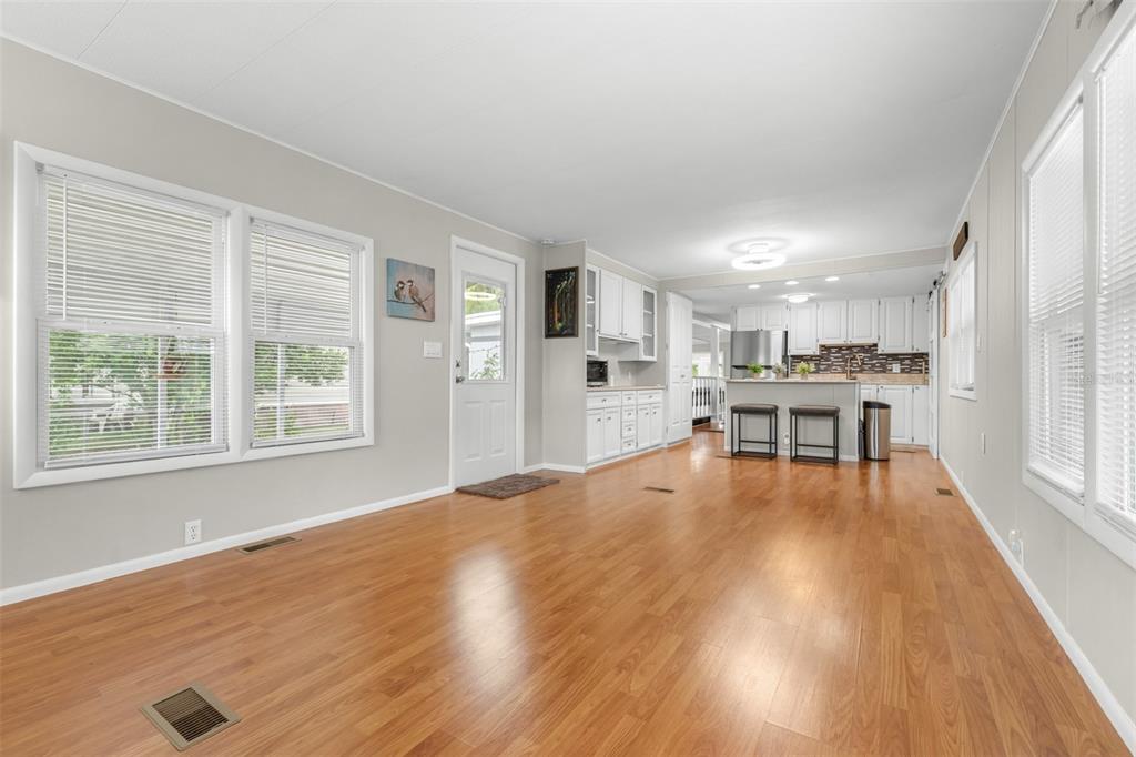 9936 East Perch Court Inverness, FL 34450 - Photo 11 of 30 a living room with a table chairs and a kitchen view with wooden floor