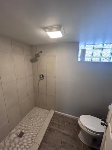 a bathroom with a toilet and a shower