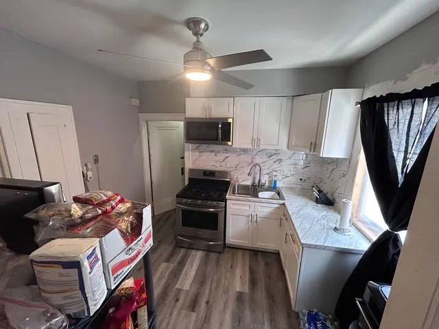 a kitchen with stainless steel appliances granite countertop a refrigerator stove and sink