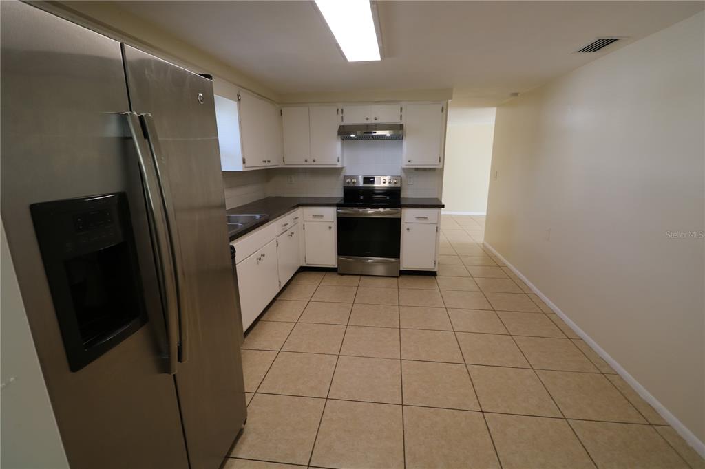 7825 Birchwood Drive Port Richey, FL 34668 - Photo 20 of 43 a large kitchen with a stove and a refrigerator