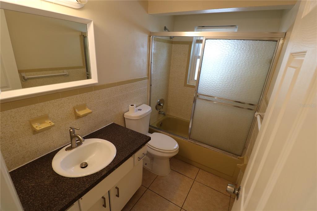 7825 Birchwood Drive Port Richey, FL 34668 - Photo 24 of 43 a bathroom with a granite countertop sink toilet and a mirror