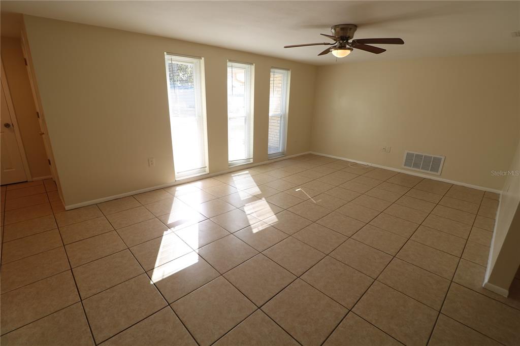 7825 Birchwood Drive Port Richey, FL 34668 - Photo 9 of 43 a view of empty room with windows
